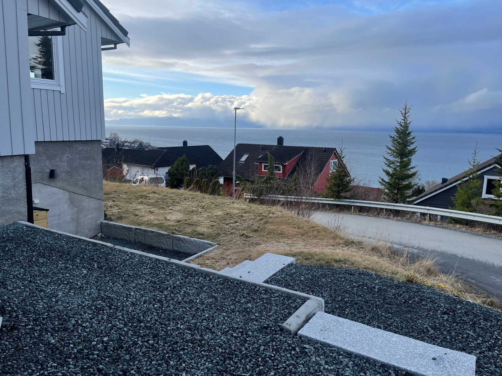 Opparbeidet uteområde med plenareal og flott utsikt mot fjord og fjell Galleribilde