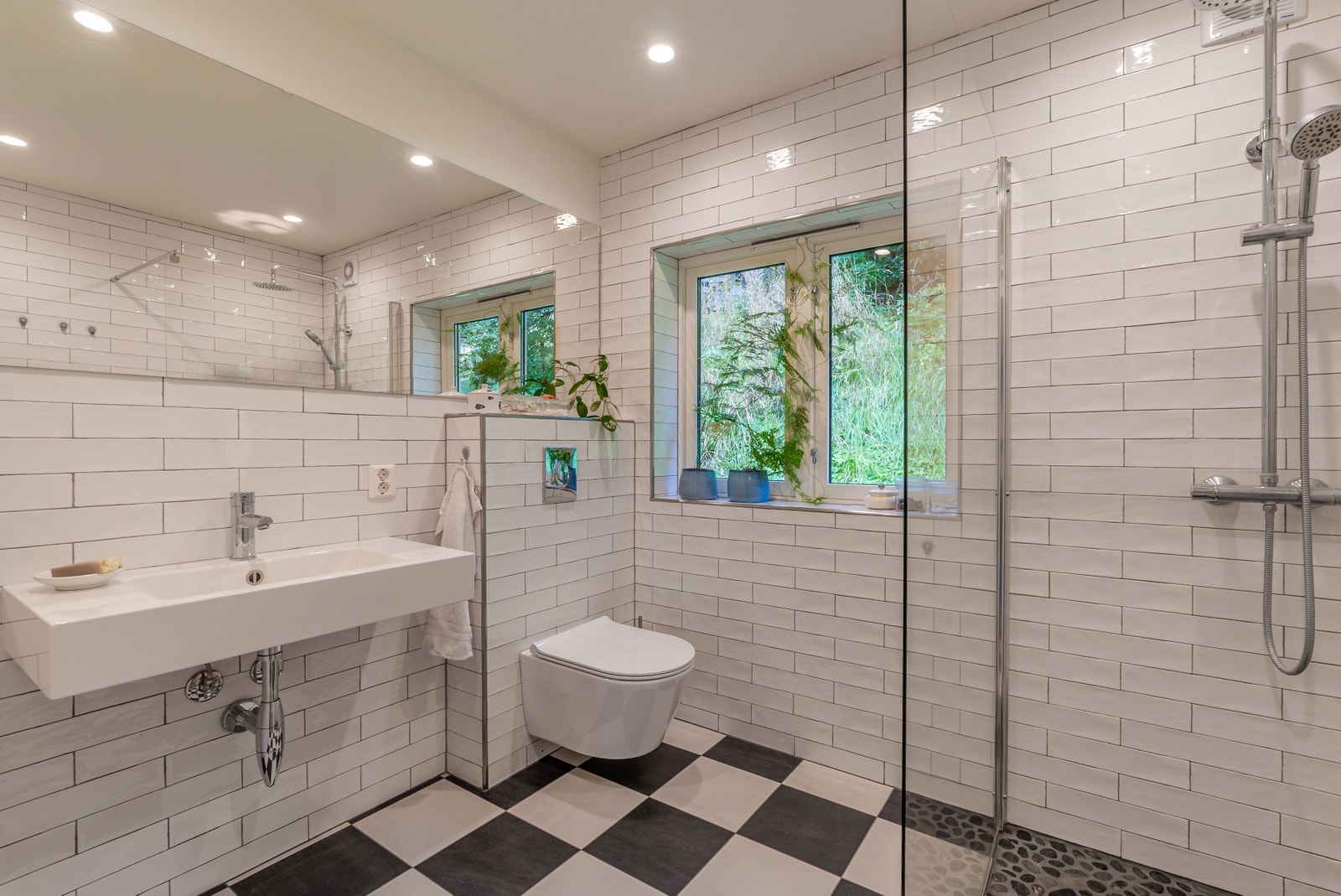 Flislagt, lyst bad med vindu mot bakhagen Galleribilde