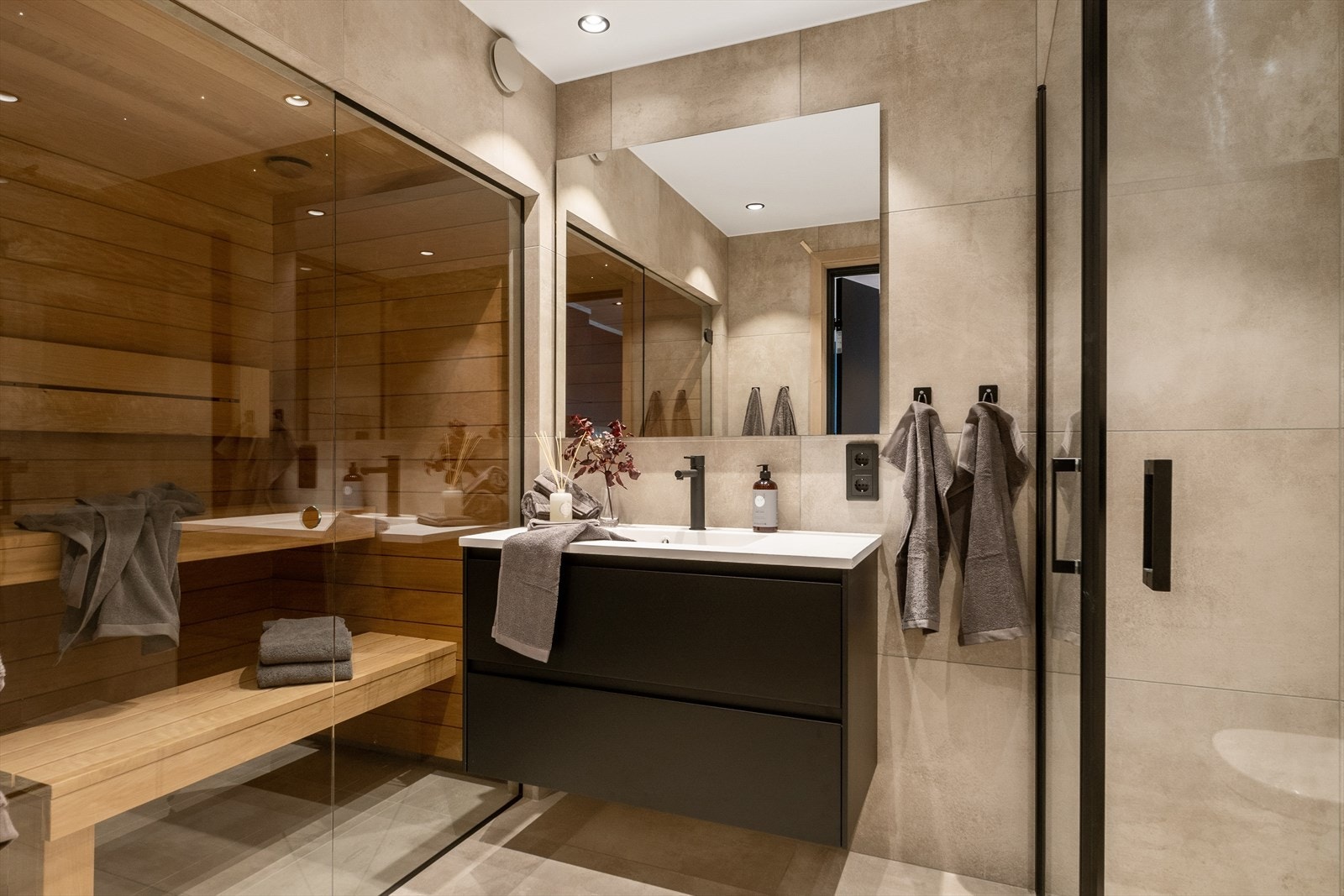 De lekre baderommene har et helhetlig og delikat inntrykk og er innredet med Ragno Studio Antracite keramiske fliser i lysgrå utførelse. Galleribilde