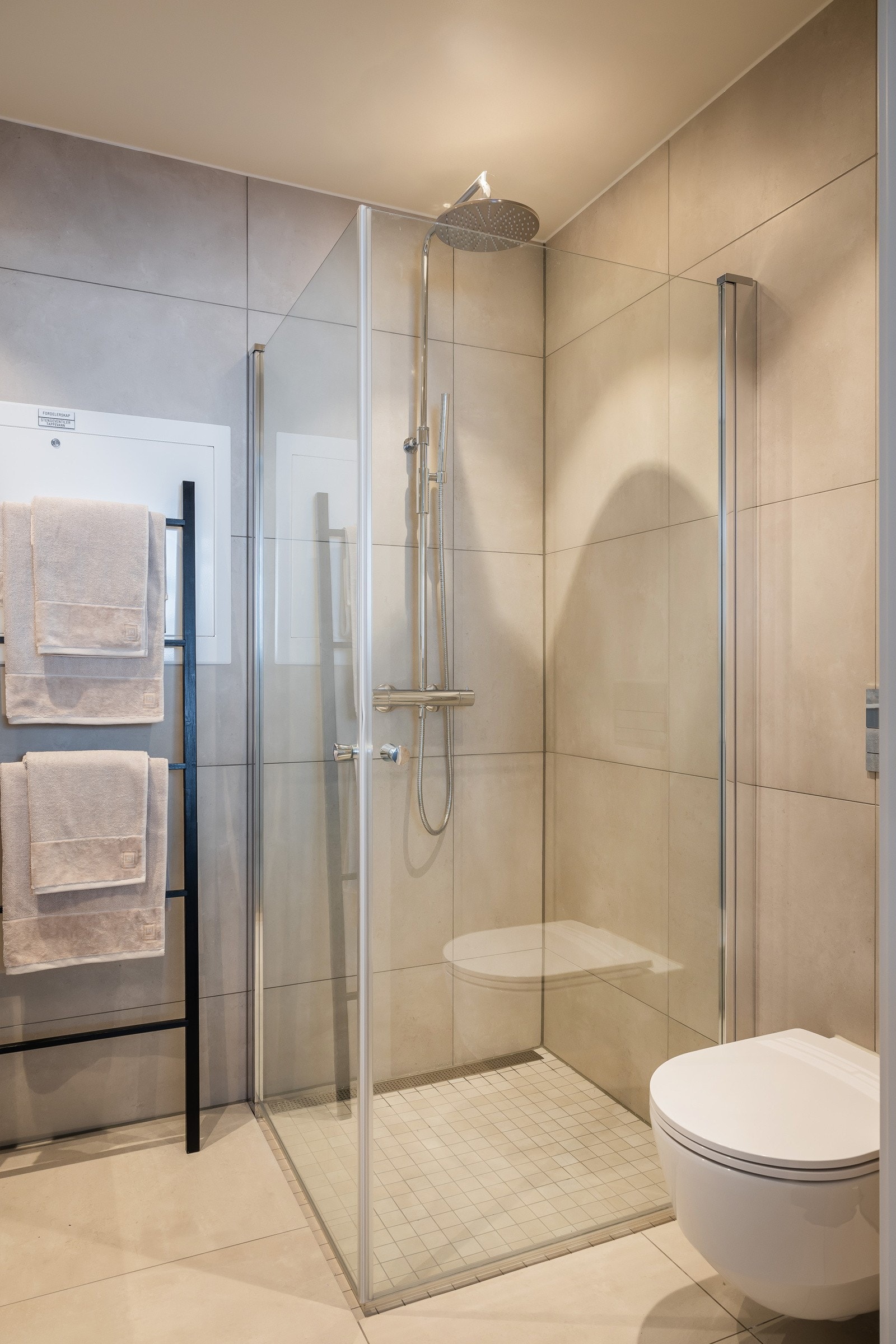 Bad 1. Alle badene i prosjektet er plassbygde med sandfargede/beige fliser 60x60 cm på vegg og gulv, foto fra Ullveien 60 Galleribilde