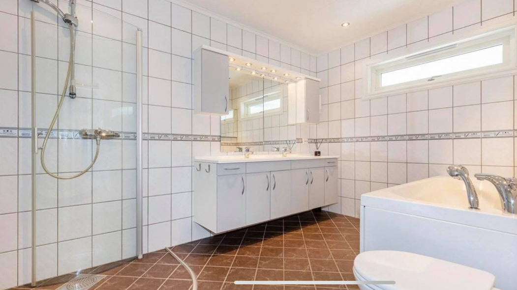 Flislagt bad i hovedetasje: dusj, badekar og dobbel servant Galleribilde