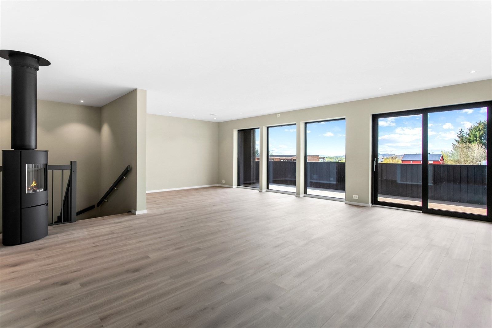 Her er det gipsbelagt vegg og tak, stilig gulv og innsatt vedovn. Store vinduer gir gode lysforhold Galleribilde