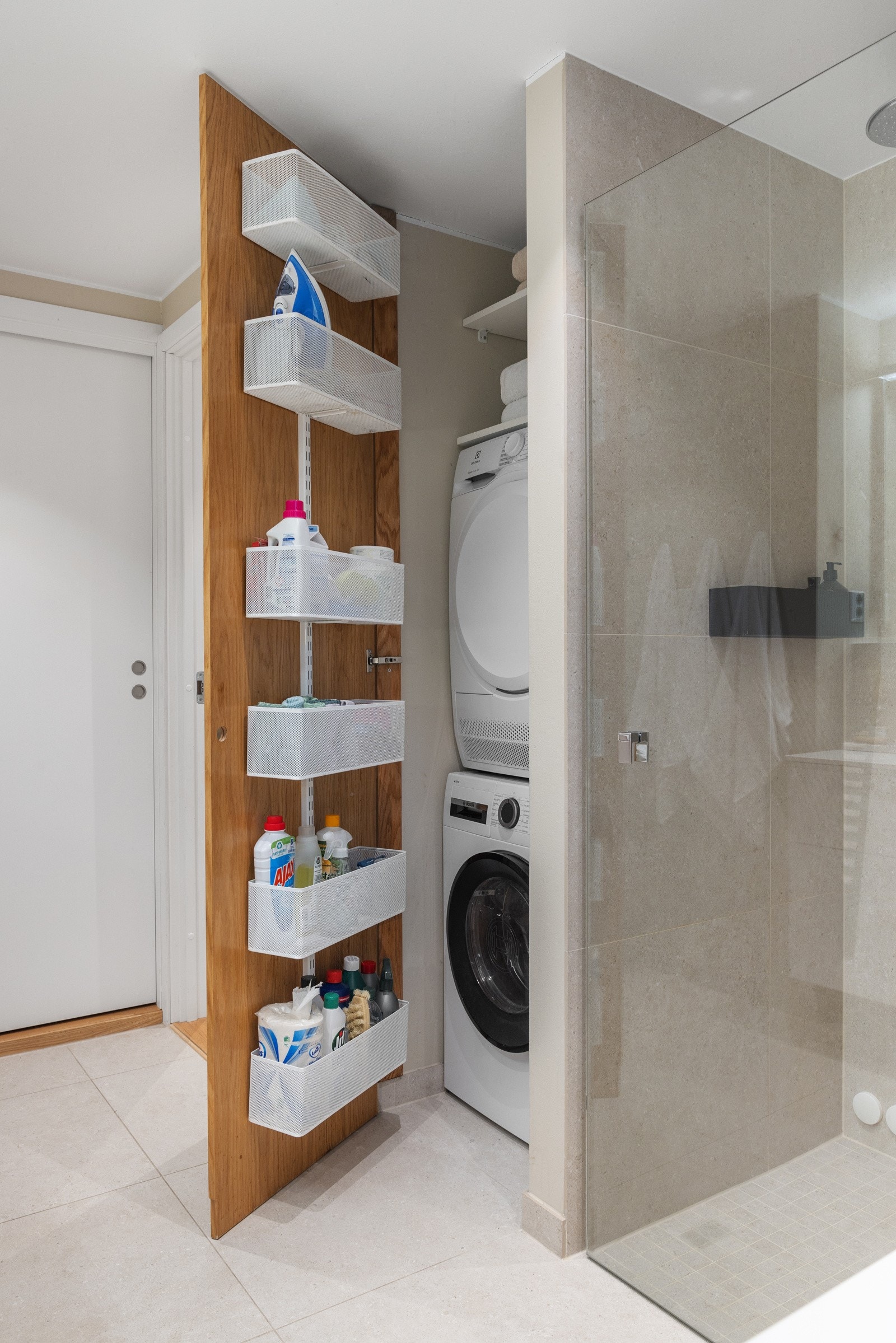 Spesialtilpasset vaskenisje med opplegg for vaskemaskin og tørketrommel. Elektrisk avtrekksvifte er installert. Galleribilde