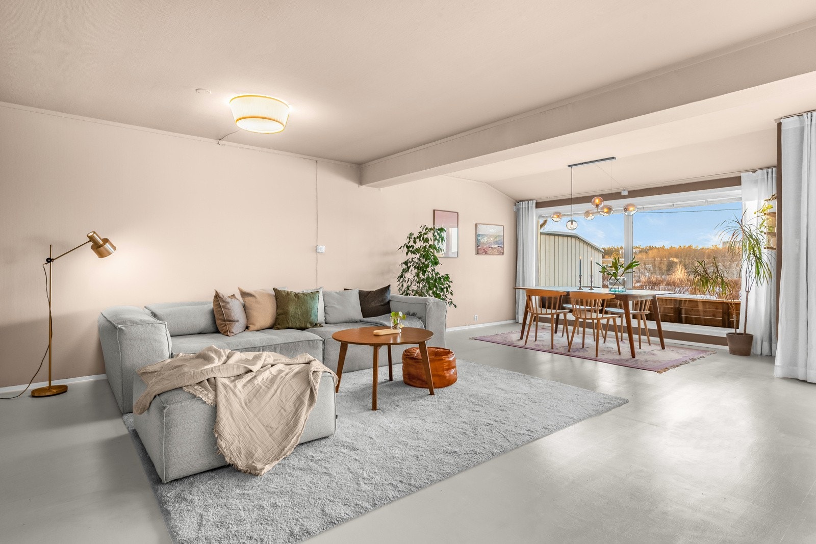 Rommet får mye naturlig lys fra store vindusflater og det er adkomst til hagen med platting via skyvedør Galleribilde