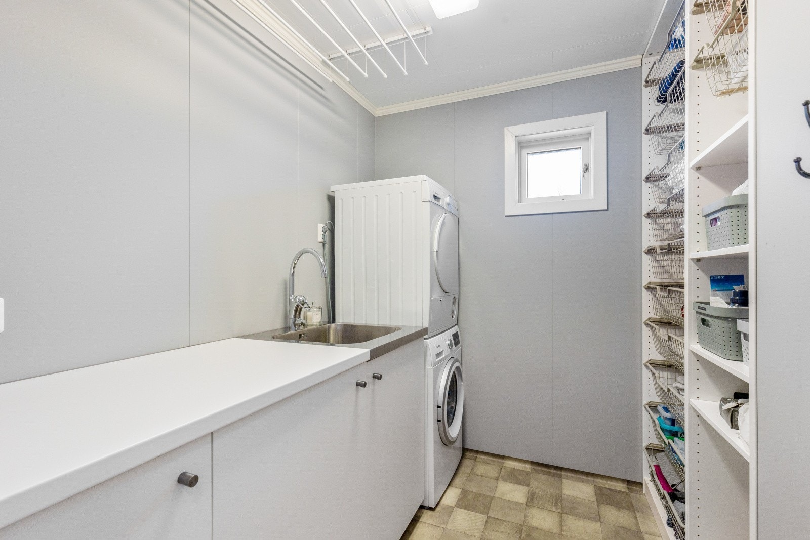 Praktisk vaskerom med opplegg for vaskemaskin og tørketrommel og gode oppbevaringsmuligheter Galleribilde