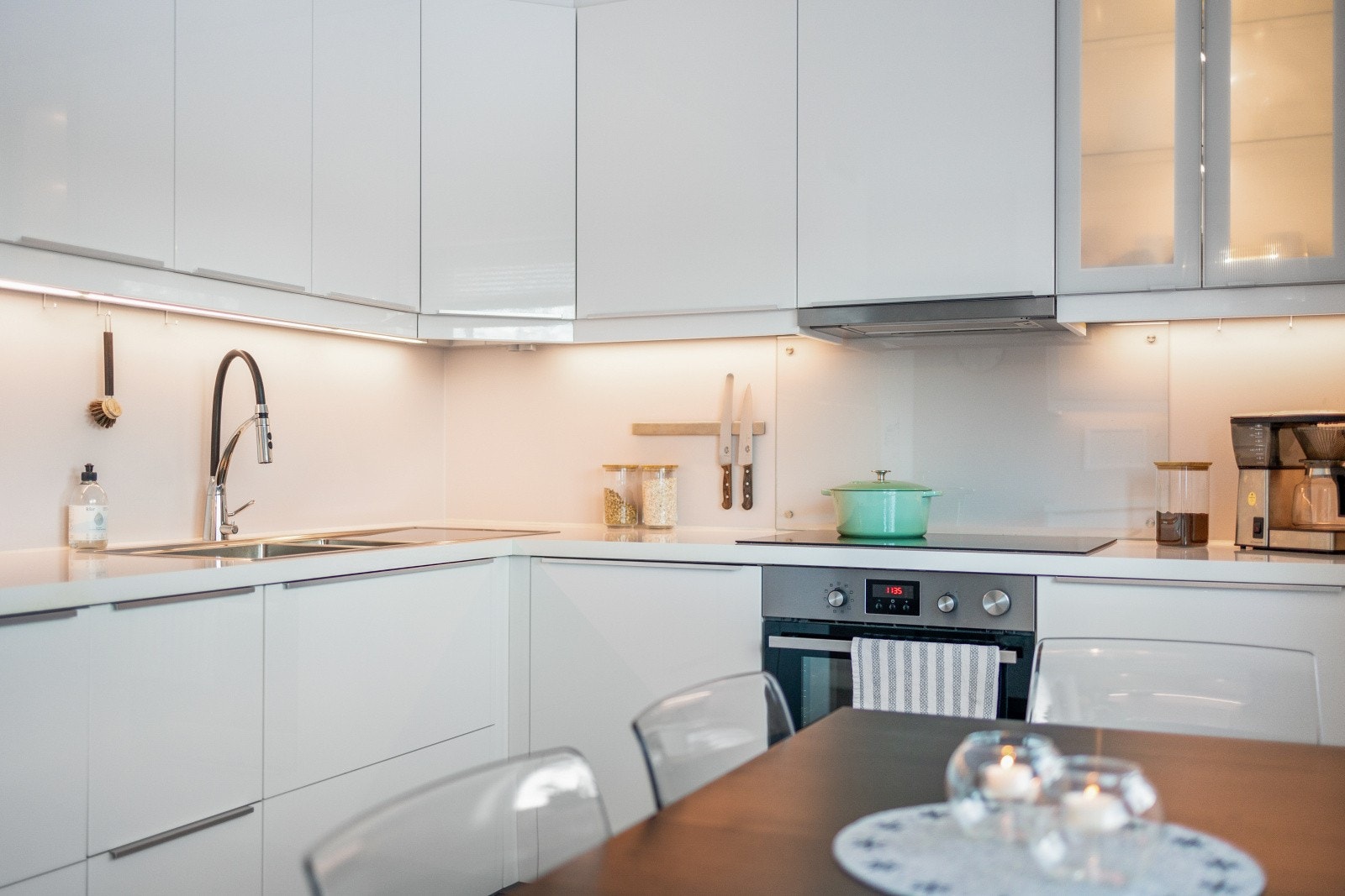 Kjøkkenet har godt med skap og benkeplass og holder et tidløst preg med sine hvite slette fronter Galleribilde