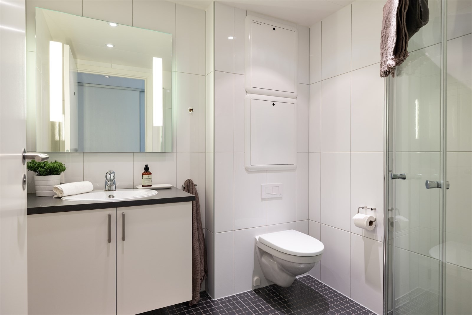 Det minste badet er på 3,5m², og ligger tilknyttet gangen. Vurdert til tilstandsgrad 1 av takstmann. Også dette flislagte badet er utstyrt med vegghengt innredning og toalett, dusjhjørne og varmekabler i gulv. Galleribilde