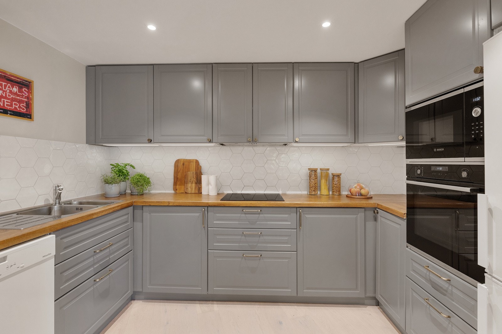 Takhøy kjøkkeninnredning med profilerte fronter, heltre benkeplate og steinplate på kjøkkenøy. Galleribilde