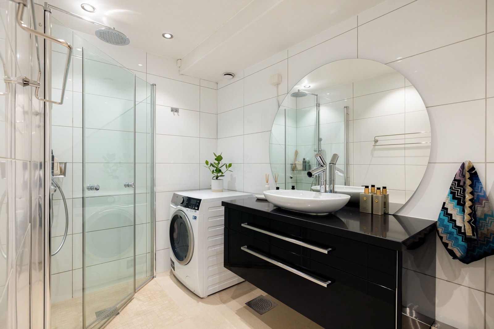 Delikat, flislagt bad/wc, bestående av vegghengt klosett, dusjhjørne med innfellbare glassdører, baderomsinnredning, armatur og speil. Ellers downlights, gulvvarme og opplegg for vaskemaskin/tørketrommel. Galleribilde