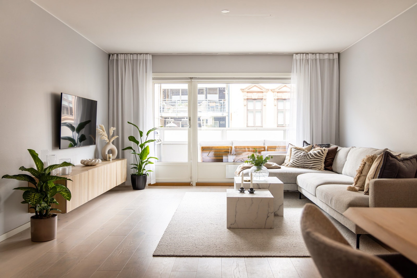 Lys og romslig stue med naturlig sofa-/tv- og spisesone. Galleribilde