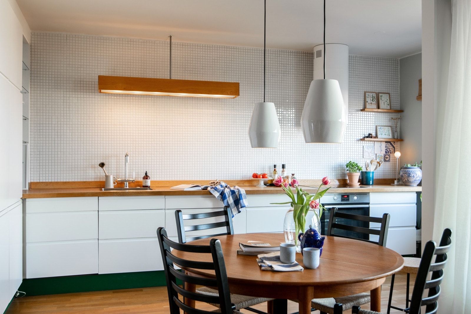 Den tidløse kjøkkeninnredningen har glatte fronter som gir et moderne uttrykk, mens benkeplaten i tre tilfører en varm og naturlig kontrast. Galleribilde