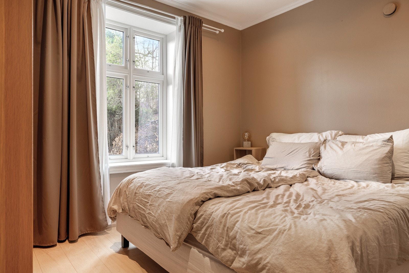 Hovedsoverommet på 10,7 kvm har plass til dobbeltseng, nattbord og er innredet med et stilrent garderobeskap fra PAX. Galleribilde