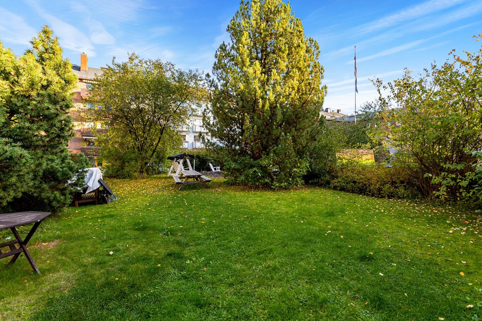 Borettslaget byr på flott og frodig felles hage med sittegrupper og beplanting Galleribilde