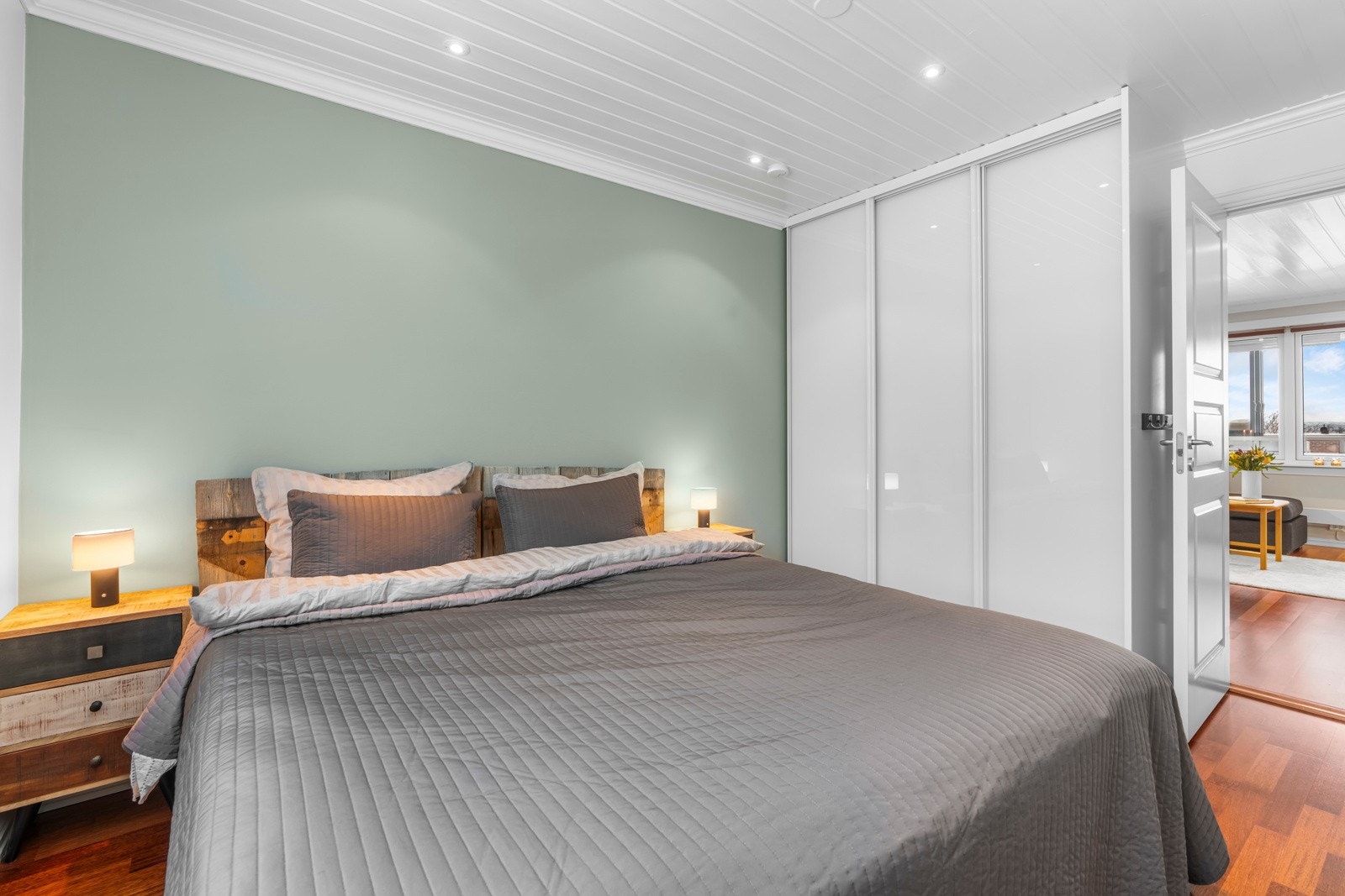 Romstørrelsen gir god plass til dobbeltseng og nattbord, og av oppbevaringsplass er det både et integrert garderobeskap og et frittstående skap. Galleribilde