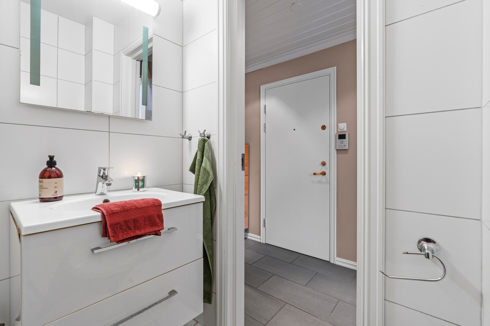 Baderomsinnredningen har benkeskap med hvite, slette fronter, heldekkende servant og speil med belysning over. Galleribilde