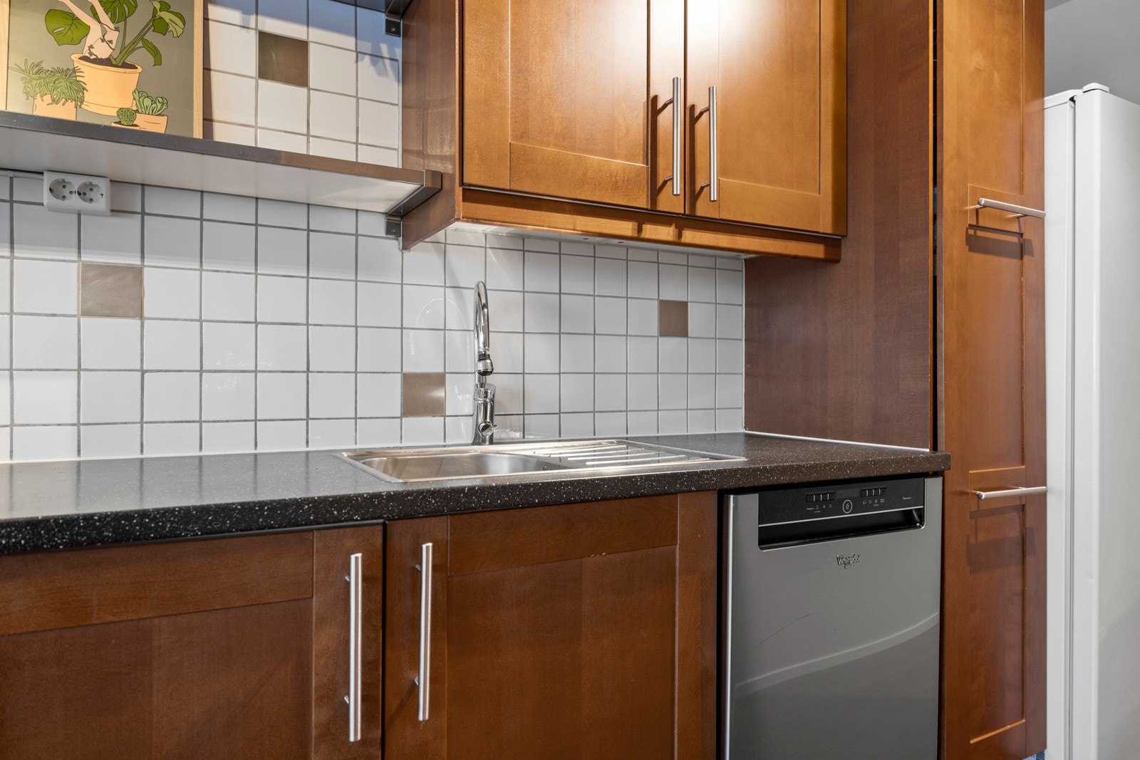 Av hvitevarer har kjøkkenet komfyr, oppvaskmaskin og en kombinert kjøl/frys Galleribilde