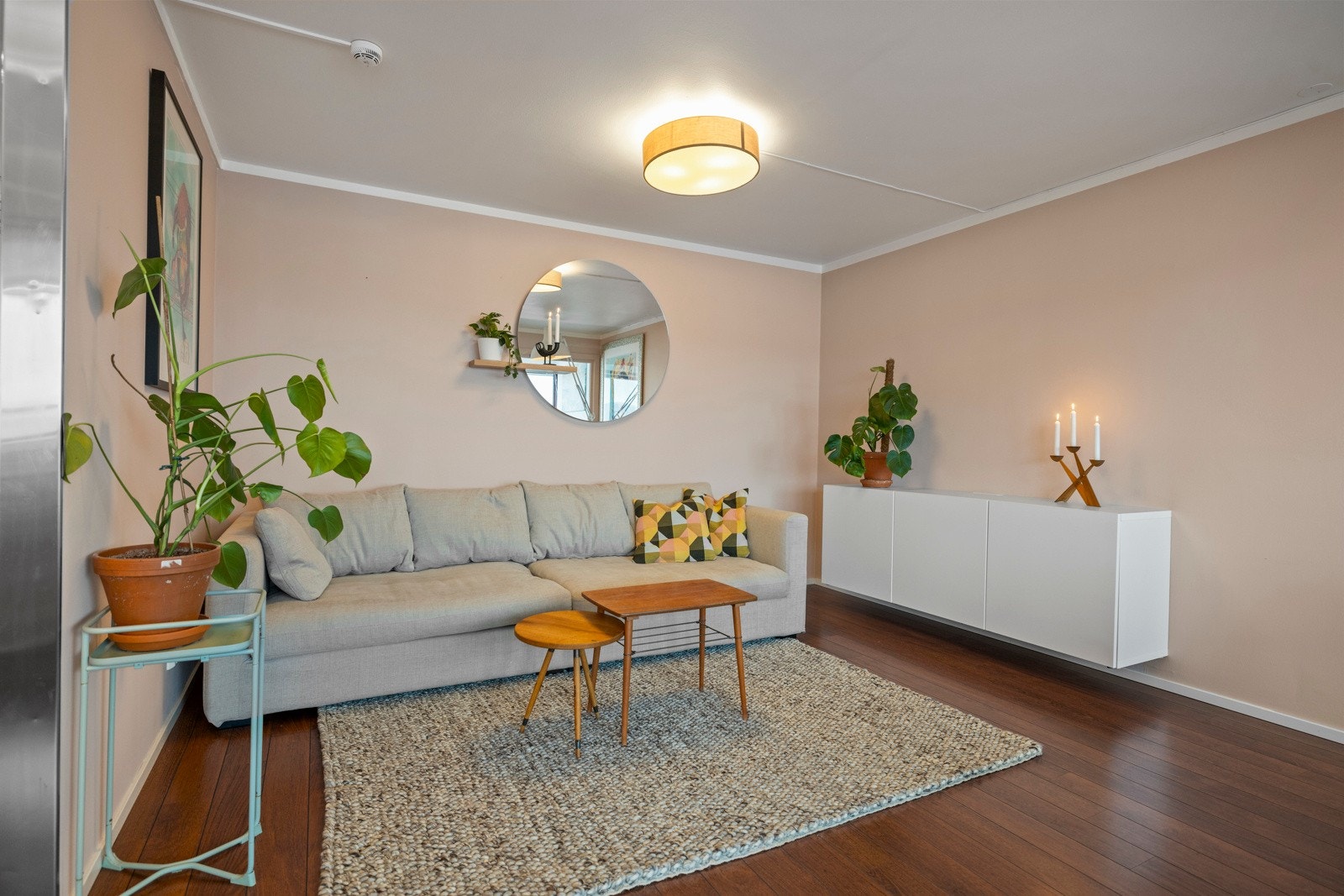 Stuen har en koselig sofakrok som er skjermet av en vegg mot kjøkkenet Galleribilde