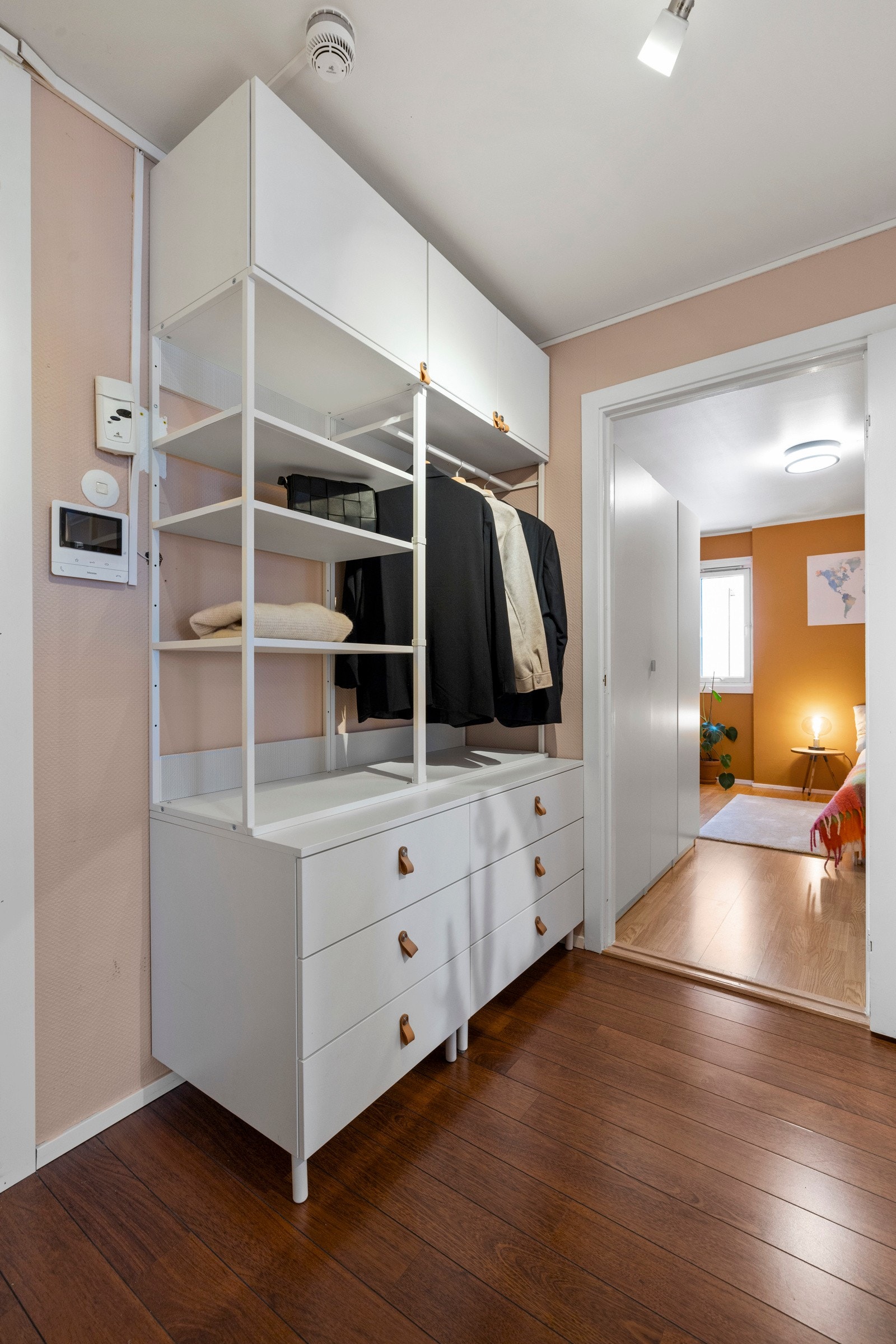 Entreen er innredet med en åpen garderobeløsning med hyller, skuffer, overskap og stang for oppheng Galleribilde