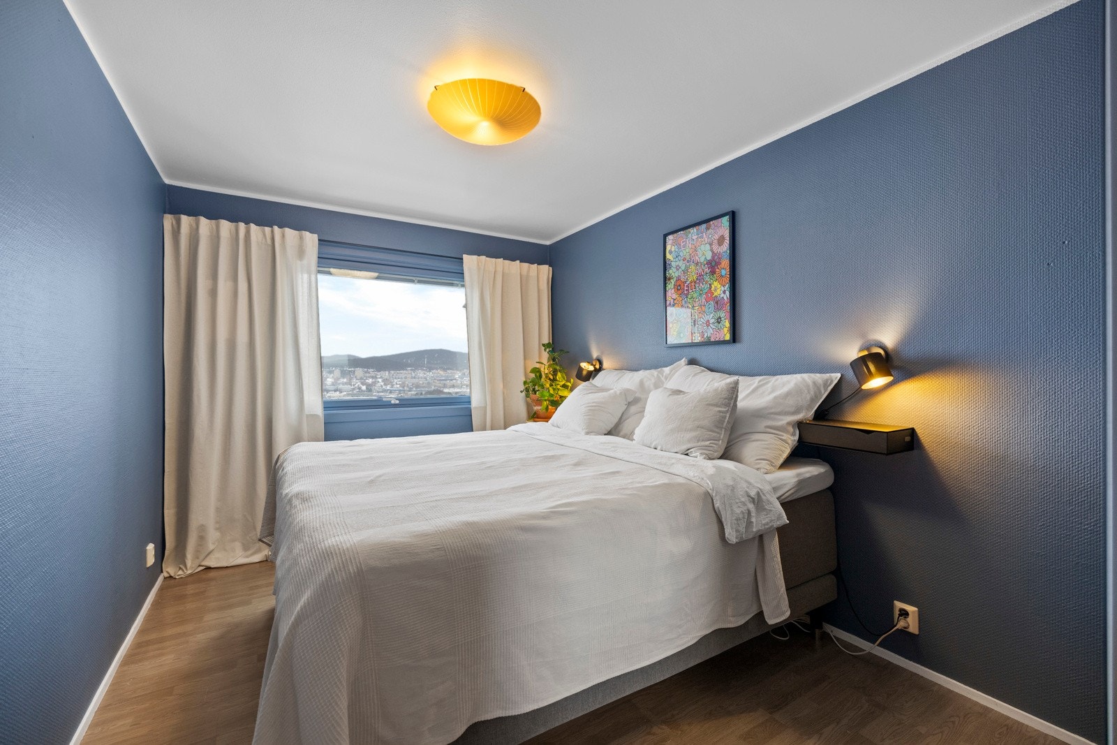 Soverommet er malt i en mørk og trendy blåfarge, noe som bidrar til en lun og avslappende atmosfære Galleribilde