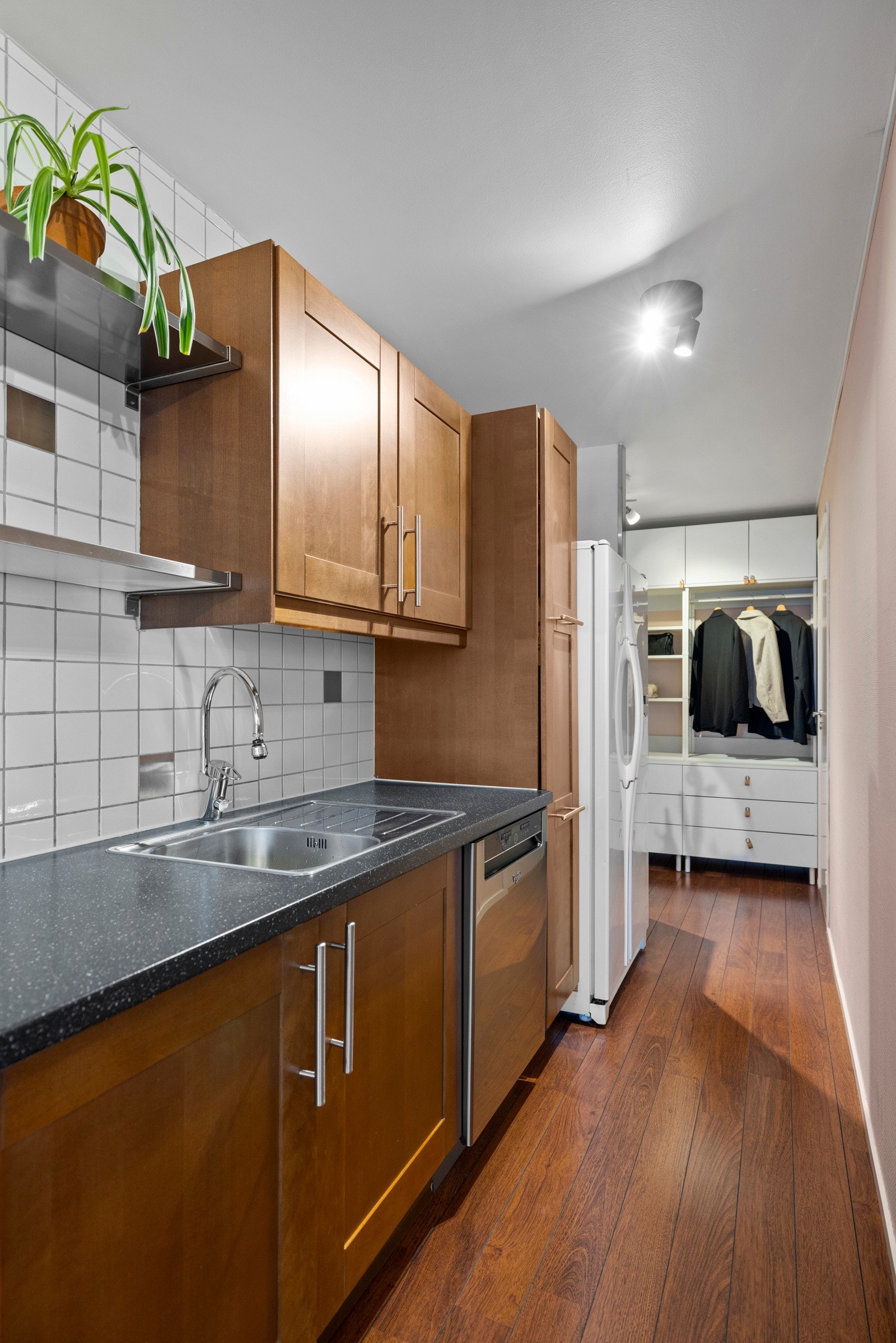 Kjøkkennnredningen har vitrineskap, profilerte fronter og benkeplate av laminat med nedfelt oppvaskkum Galleribilde