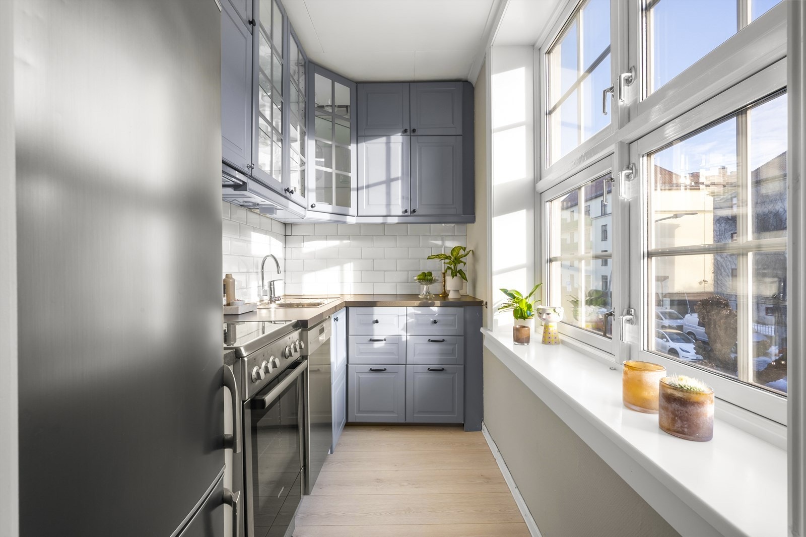 Innredningen med profilerte fronter, enkelte fronter med glassfelt, fliser over kjøkkenbenk og laminat benkeplate. Galleribilde