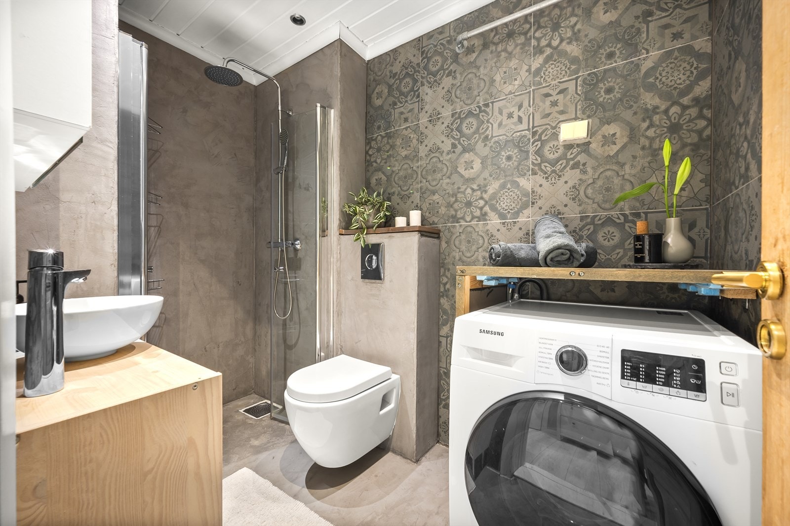 Lekkert bad med en kombinasjon av mikrosement og fliser på overflatene, gulvvarme og innfelte downlights i himling. Galleribilde