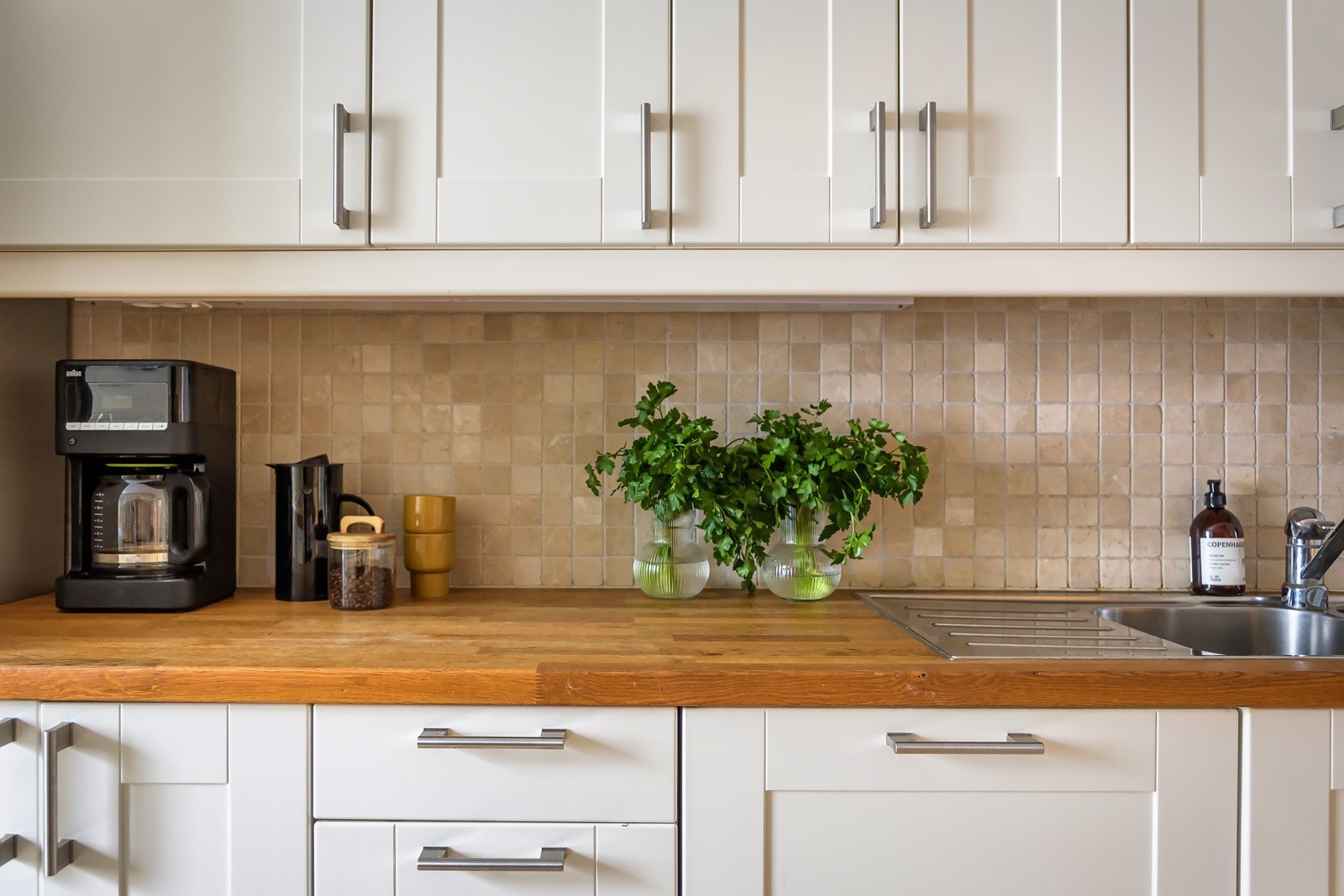 Både fint og praktisk med fliser i benkeryggen og belysning under overskapene. Galleribilde