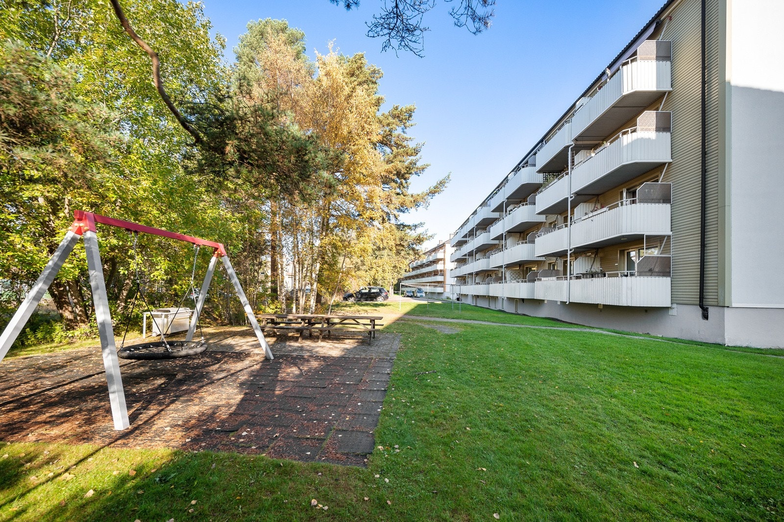 Pent opparbeidet fellesarealer med gressplener, asfalterte veier, lekeplass og sittebenker. Galleribilde