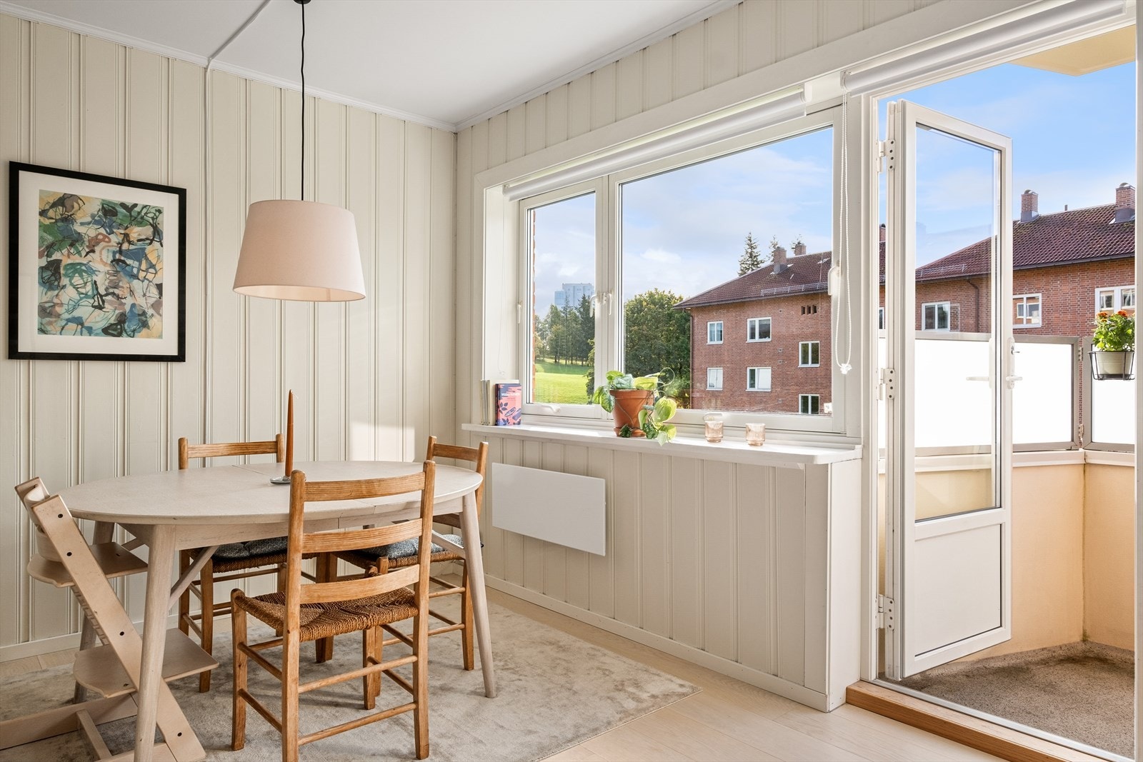 Sommerbilde av stue med solrik balkong og utsikt over Torshovdalen. Galleribilde