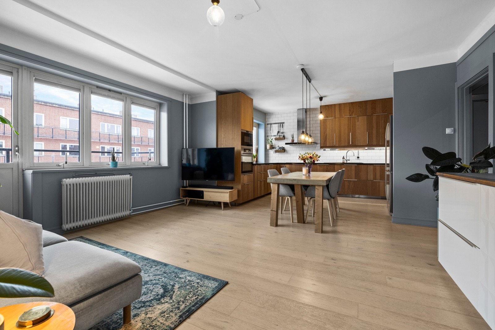 Stor åpen stue-/ kjøkkenløsning. De store vindusflatene slipper inn godt med naturlig lys. Galleribilde