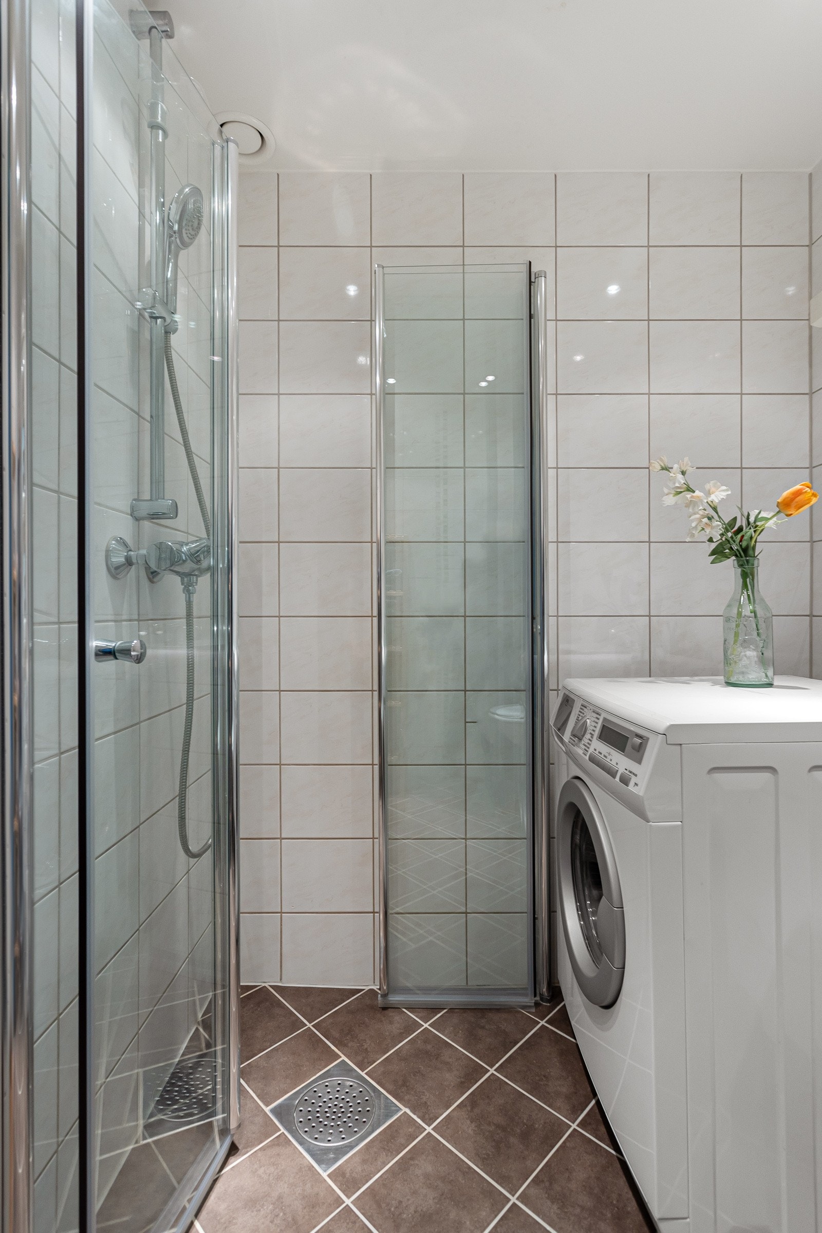 Badet ble pusset opp i regi av borettslaget i 2014, og har et vegghengt toalett, opplegg for vaskemaskin og et dusjhjørne med innfellbare glassdører Galleribilde