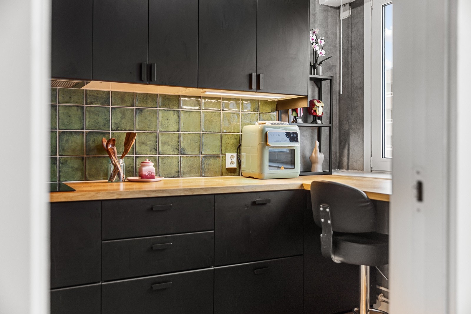 Innredningen fra Ikea har sorte, glatte fronter og lys laminatbenkeplate med nedfelt kum i sort kompositt Galleribilde