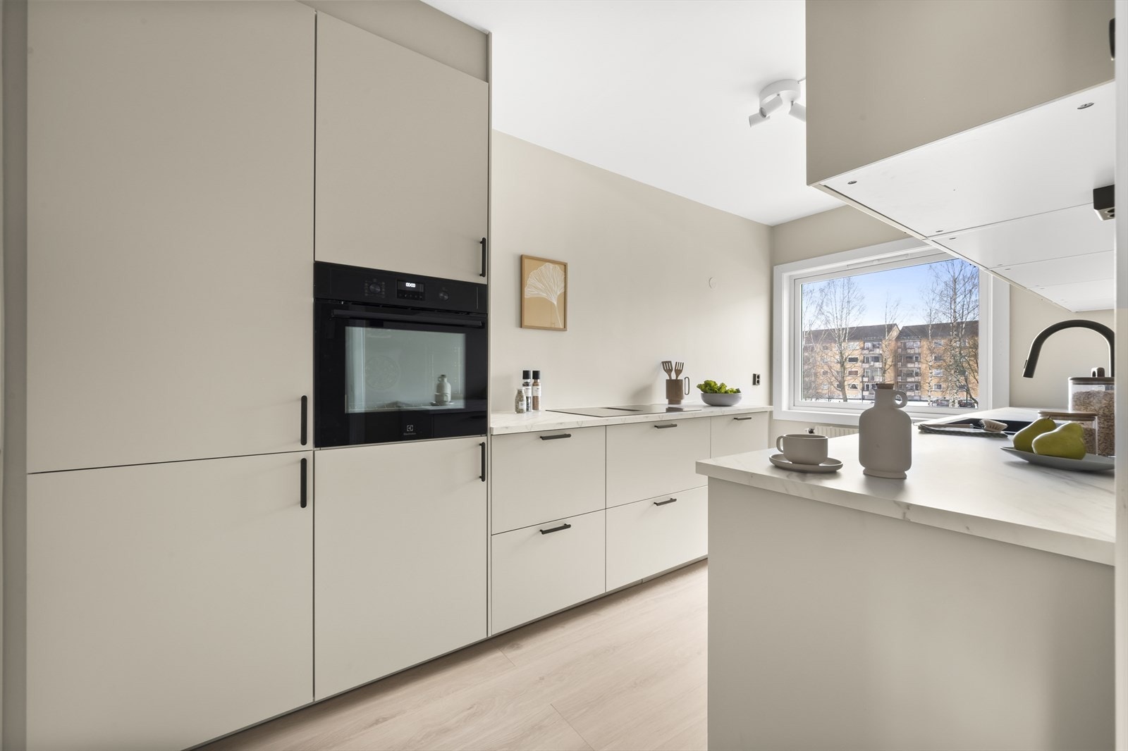 Stilsikkert Ikea-kjøkken fra 2025 med tidsriktig innredning med lyse, glatte fronter og benkeplate i laminat. Galleribilde