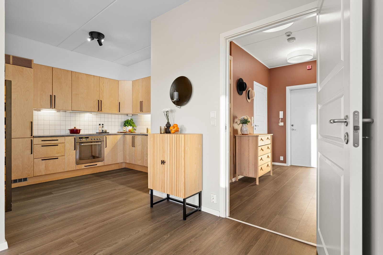 Kjøkkeninnredningen er oppført i en funksjonell L-form med glatte fronter og benkeplate av laminat Galleribilde