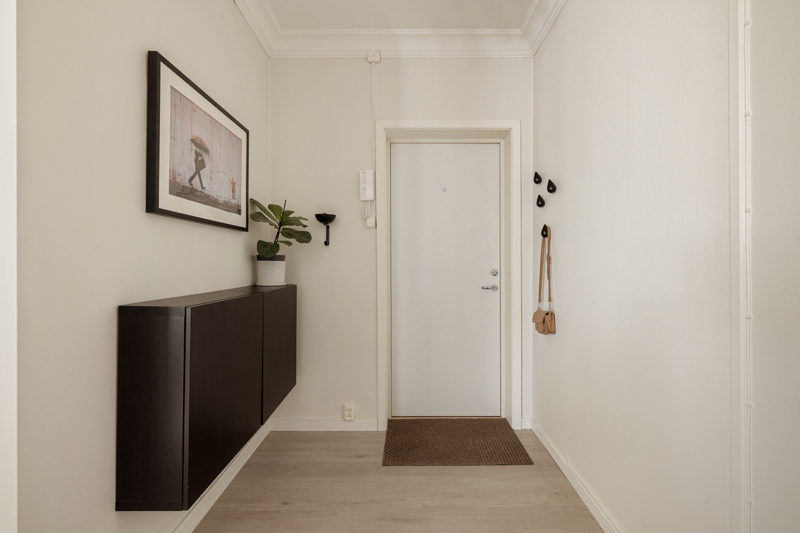 Du kommer inn i den lyse entreen, som har 1-stavs laminat på gulv noe som er gjennomgående i boligen. Her er det plass til å henge fra seg yttertøyet, samt innrede med skostativ og knagger. Galleribilde