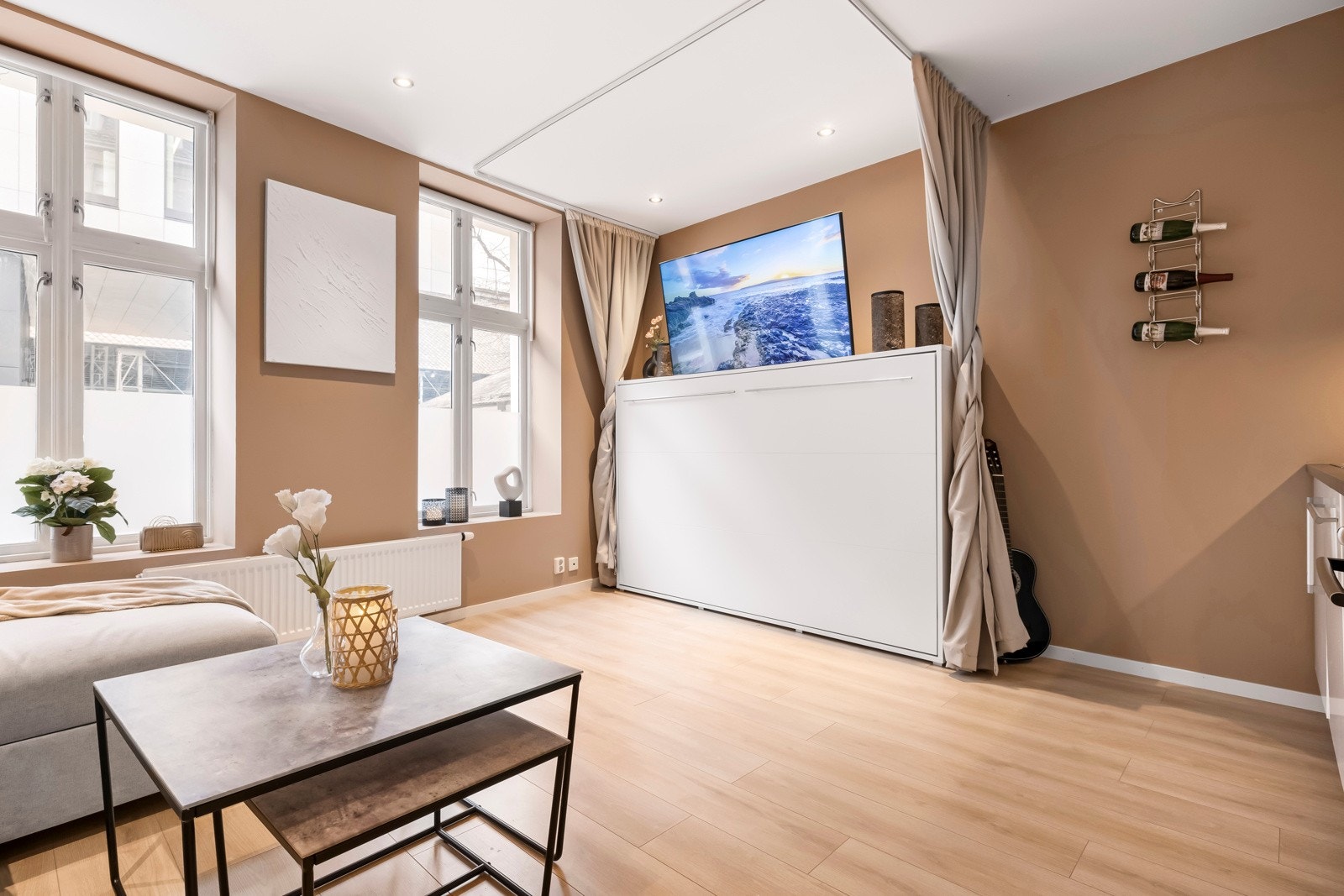 - Selger har montert vegghengt seng som på dagtid fungerer som tv-benk, men som om kvelden trekkes ned til seng - Galleribilde