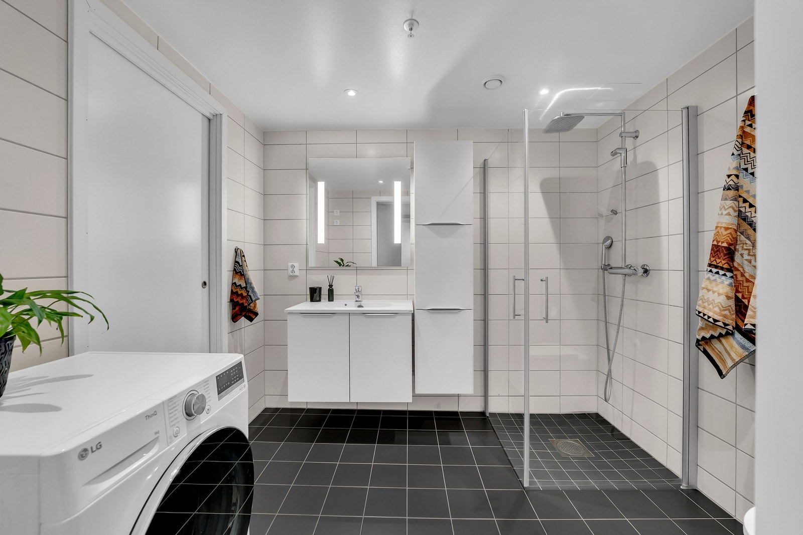 Innredningen består av heldekkende servant, speil med belysning, veggmontert toalett og dusjnisje med innfellbare glassdører og regnfallsdusj. Galleribilde