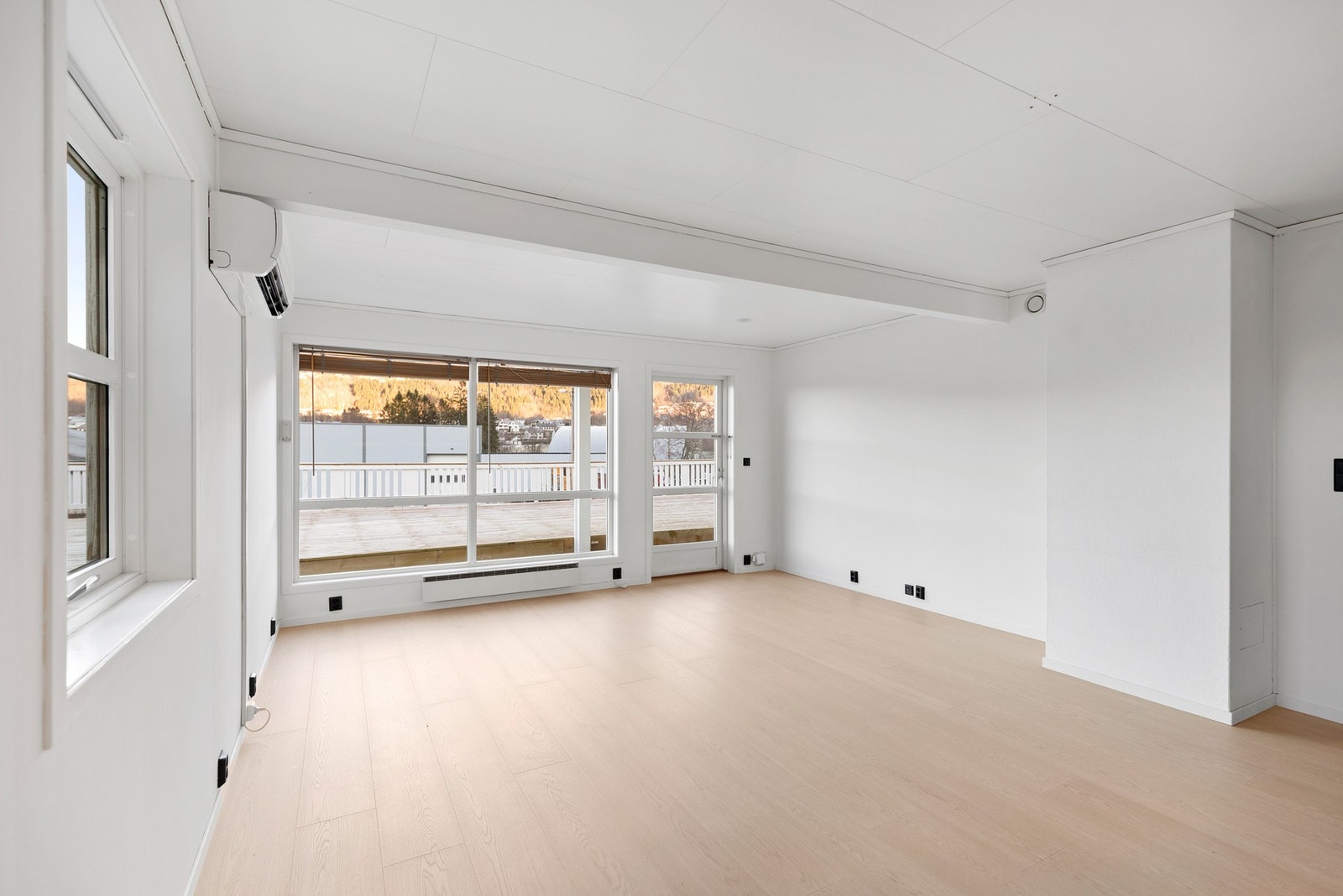 Stuen ligger i arealeffektiv, åpen løsning med kjøkkenet og har flere, store vindusfelt som gir mye naturlig lys og en god romfølelse Galleribilde