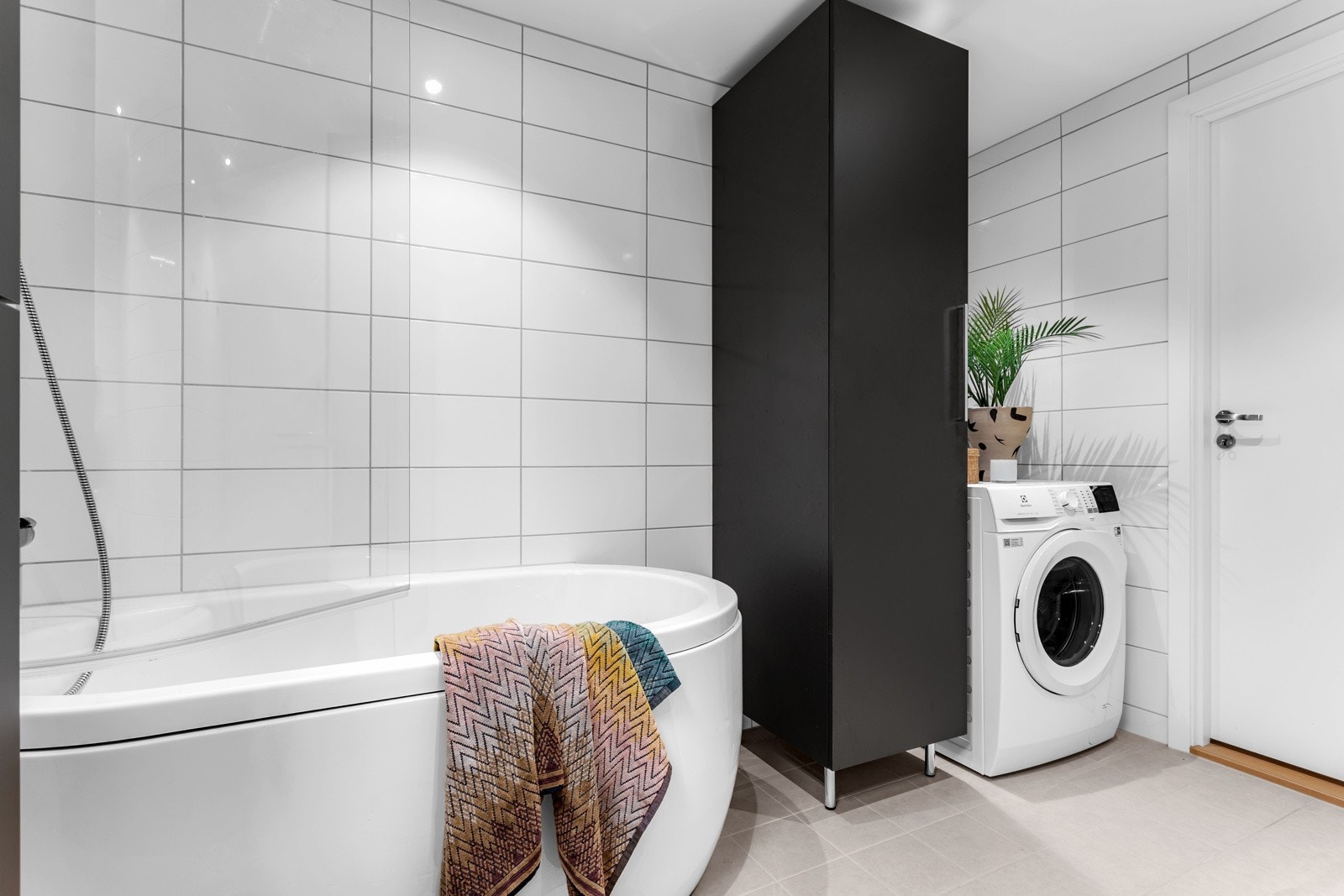 Hovedbadet fremstår meget romslig med plass til badekar og vaskemaskin. Galleribilde