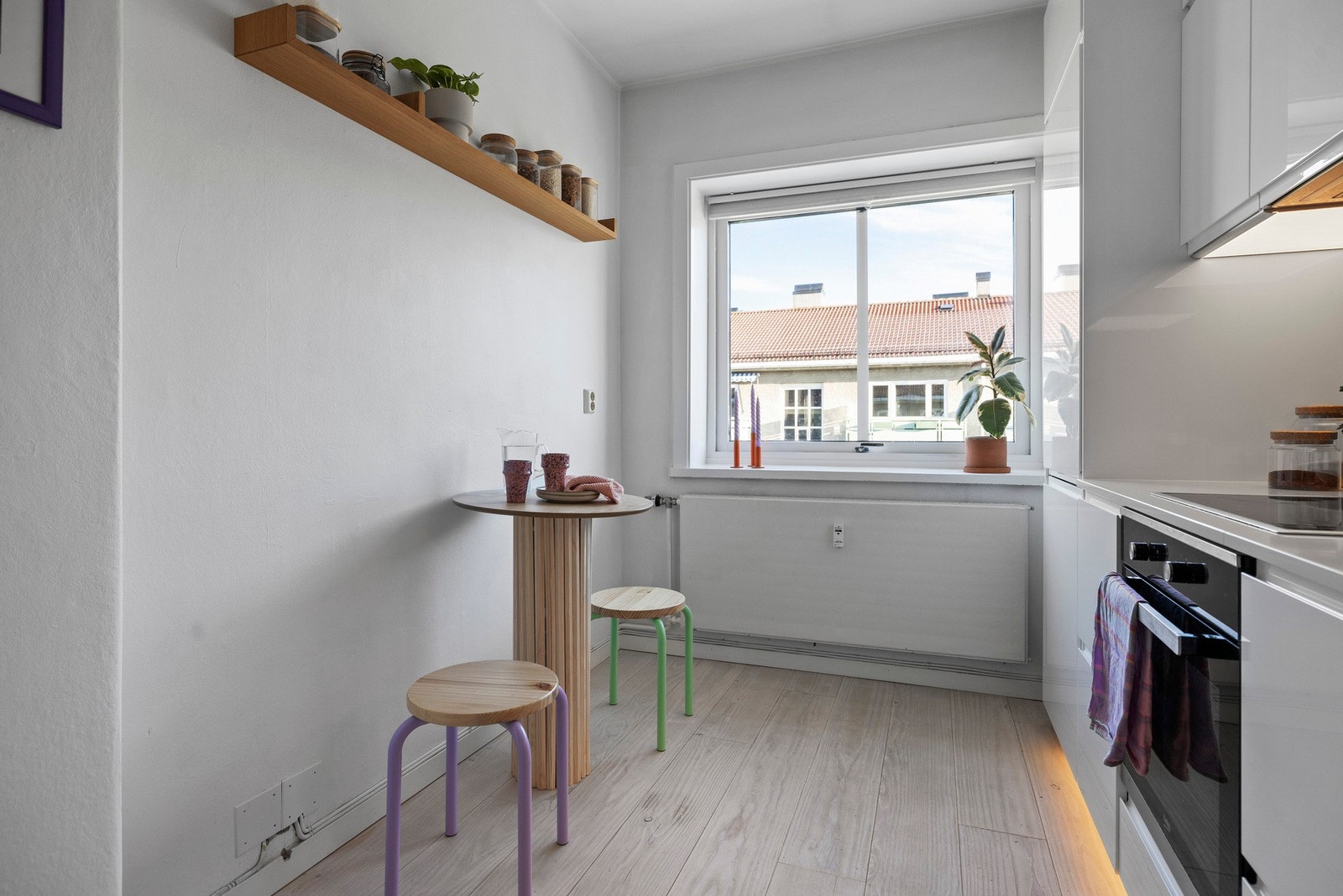 Et lyst og koselig kjøkken med plass til et lite spisebord - perfekt for hverdagslige måltider. Galleribilde