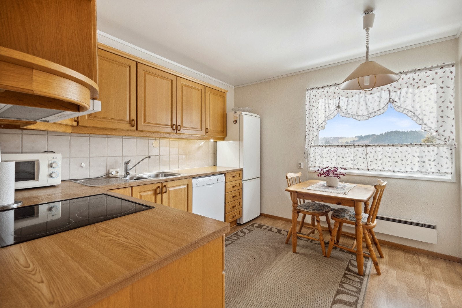 Praktisk kjøkken i eget rom med et areal på 9 kvm, hvor det også er plass til et koselig frokostbord. Galleribilde