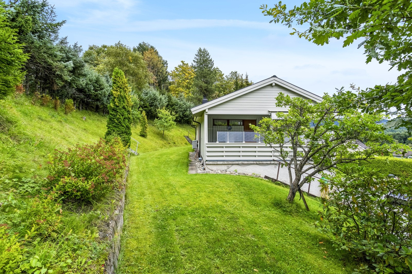 På sommerstid byr eiendommen på flotte grøntområder og rikelig med boltreplass. Galleribilde