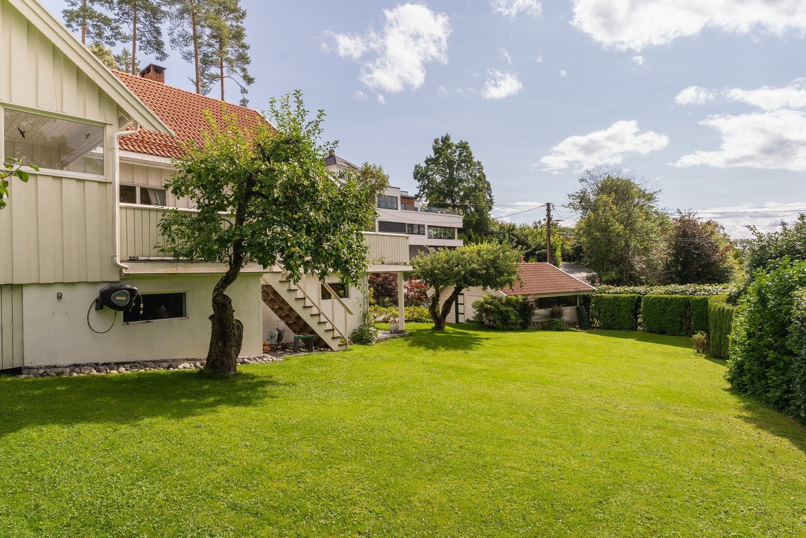 Solrik tomt på 1 mål. Flere hyggelige uteplasser med trapp ned til hagen. Her har du et romslig hus for hele familien. Galleribilde