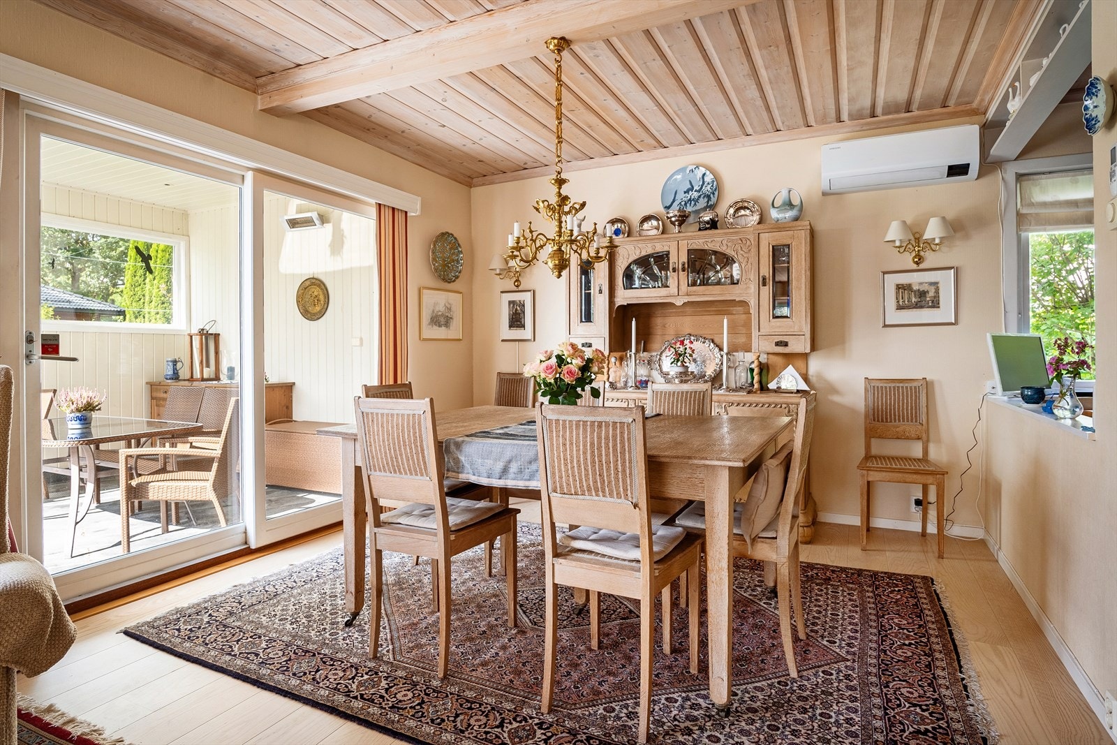 Fra spisestuen er det via stor skyvedør adkomst til den vestvendte delen av terrassen med ettermiddag- og kveldssol. Varmepumpe montert på vegg. Galleribilde