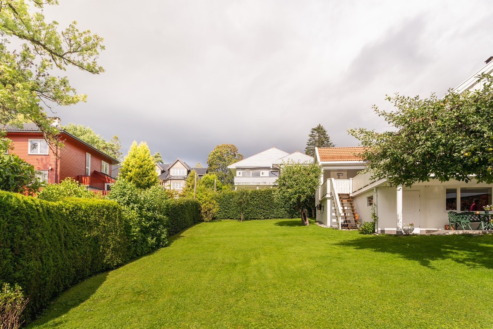 Eiendommen ligger fint til omkranset av trær og fyldige hekker. Her kan barna leke fritt i egen skjermet hage. Galleribilde