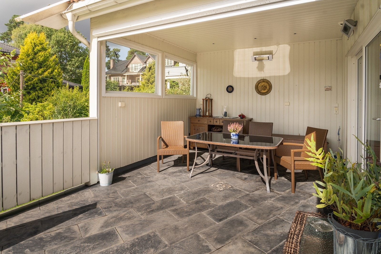 Hyggelig overbygget del av terrassen. Her kan man nyte utsikten og solen store deler av året. Skillevegg som skaper et ekstra lunt rom. Varmelamper og downlights. Galleribilde