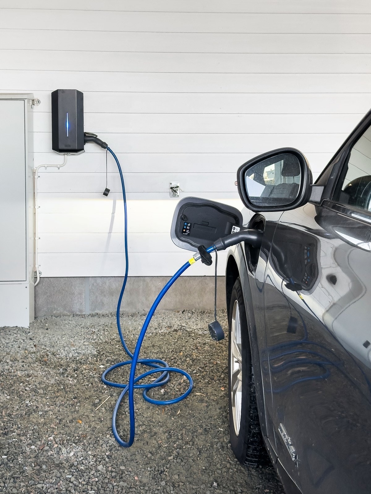 Elbil-lader montert i carport. Det er også en bod i bakkant av carporten. Galleribilde
