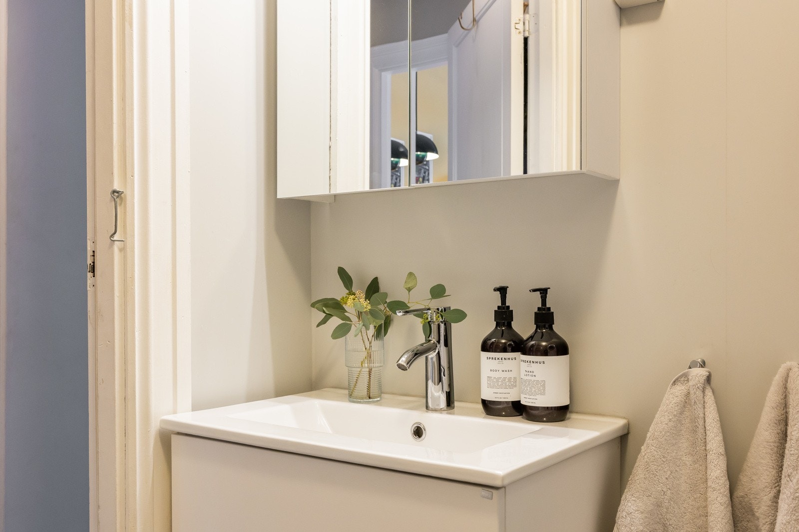 Moderne baderomsinnredning fra 2021 med heldekkende servant og speilskap. Galleribilde