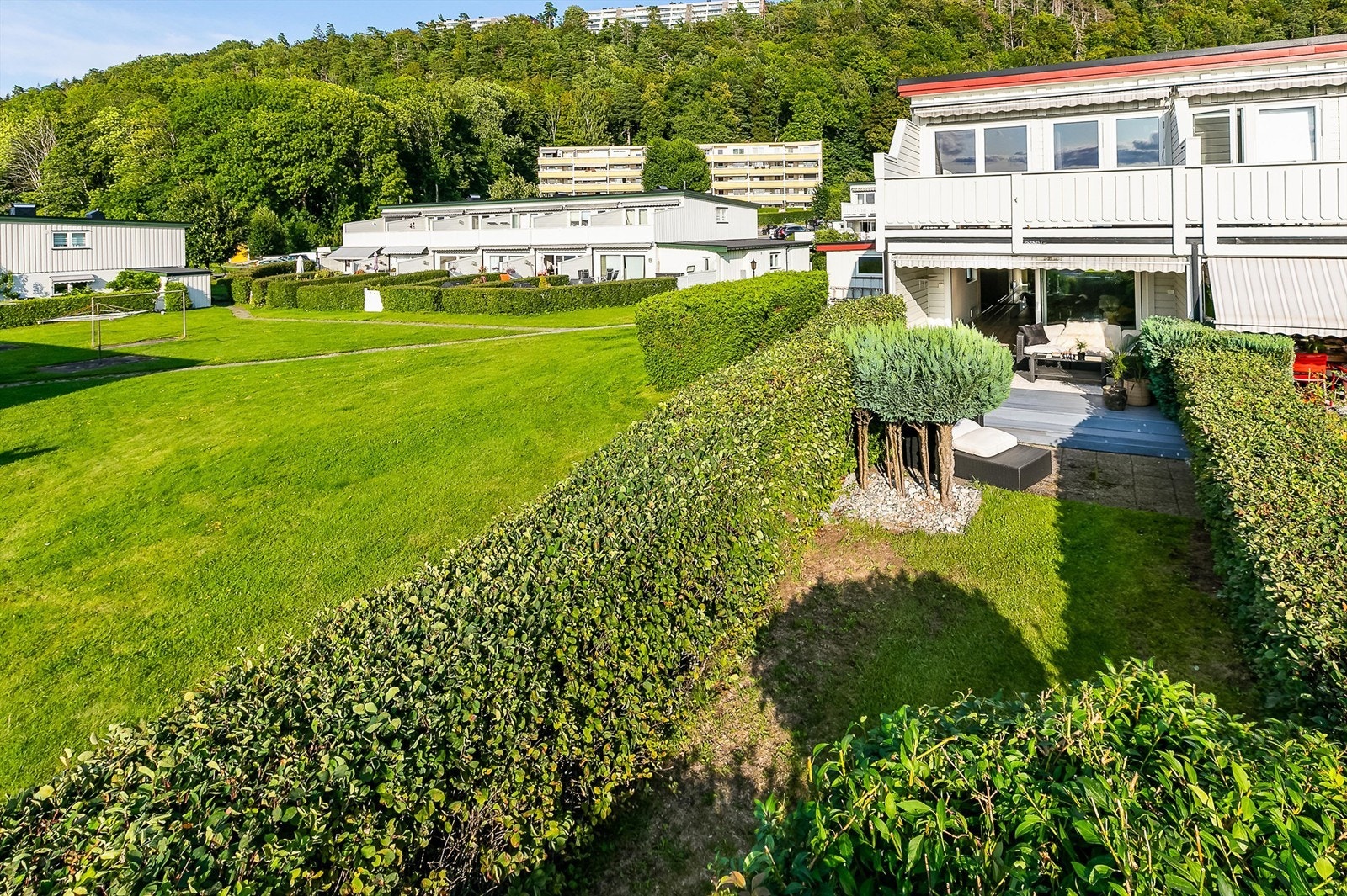 Tettvoksende hekk rammer inn boligens tilknyttede hage. Galleribilde