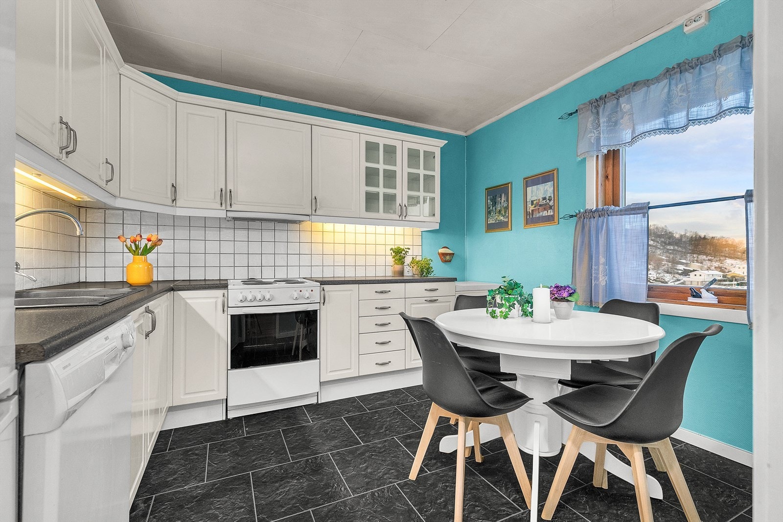 Kjøkkenet har innredning med hvite profilerte fronter. Her er det også plass til spisegruppe. Galleribilde